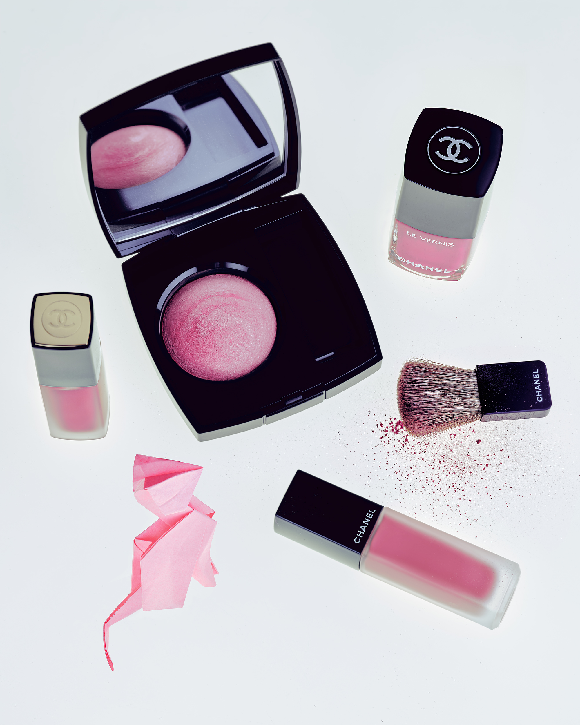 Flat lay of Chanel makeup products including blush, nail polish, and lipstick. 